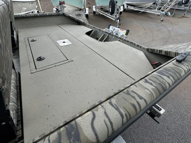 Slide: The Image of 2025 SeaArk Shadow 20 Elite CC boat deck with storage compartments, featuring a camouflage pattern. - 16