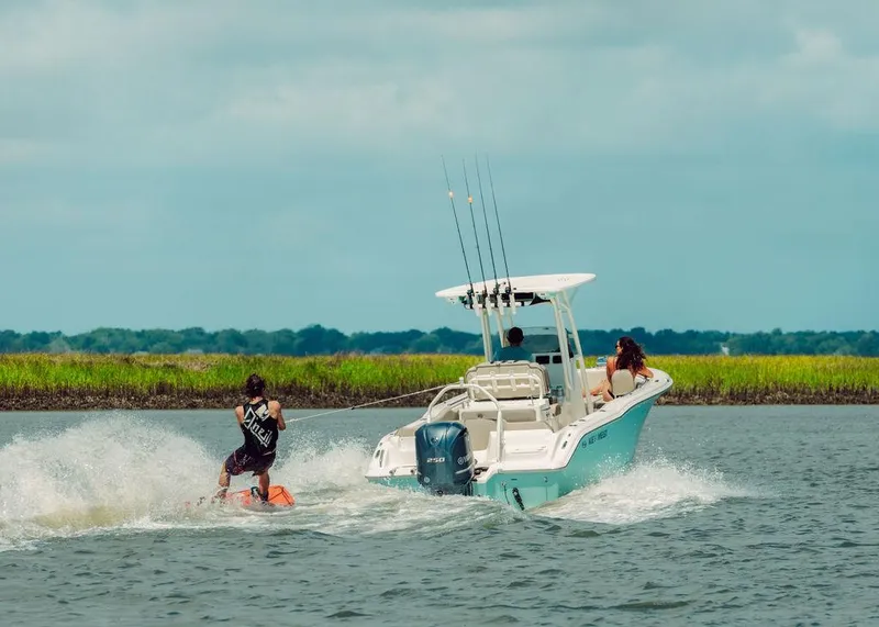 Slide: The Image of 2025 Key West 239FS boat towing a wakeboarder on a sunny day. - 6