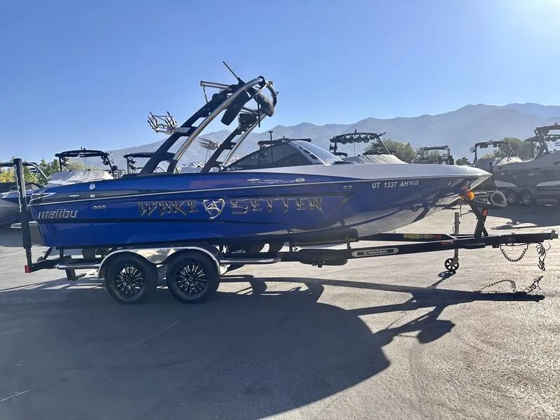 Slide: The Image of 2013 Malibu Wakesetter 21 VLX boat on trailer, sunny day, mountain backdrop. - 11