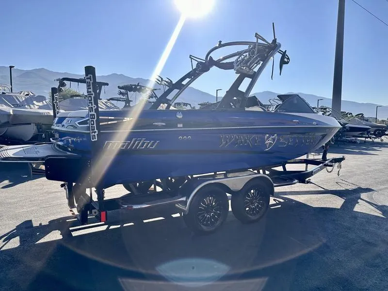 Slide: The Image of 2013 Malibu Wakesetter 21 VLX boat on trailer in sunny outdoor setting. - 13