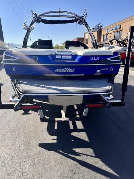 Slide: The Image of 2013 Malibu Wakesetter 21 VLX boat, blue exterior, parked on trailer. - 5