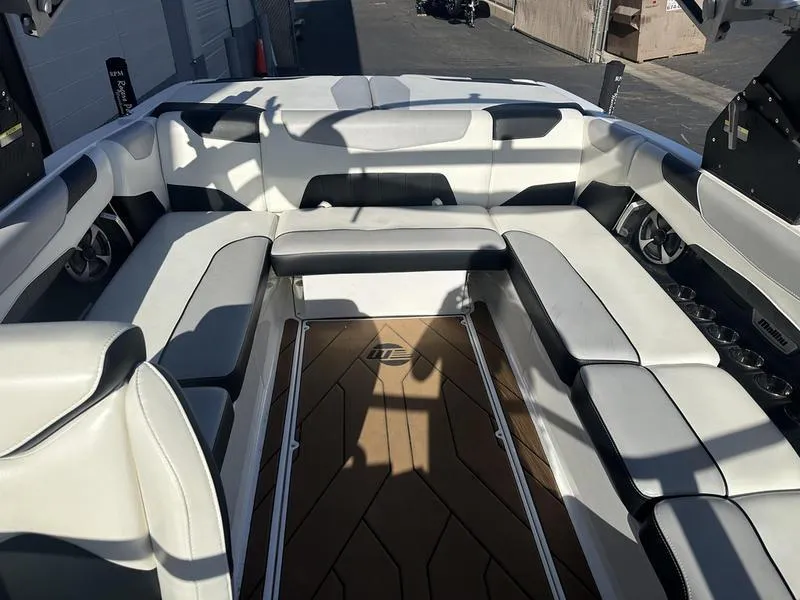 Slide: The Image of 2020 Malibu 23 LSV boat interior with white seating and wood flooring. - 4