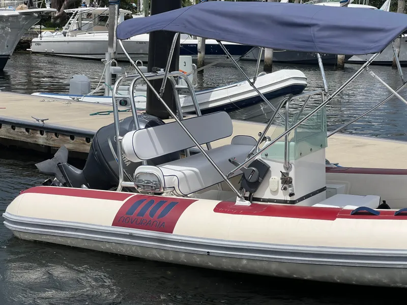 Slide: The Image of Novurania DL 550 2003 Hull boat docked, featuring canopy and seating, year 2016. - 2