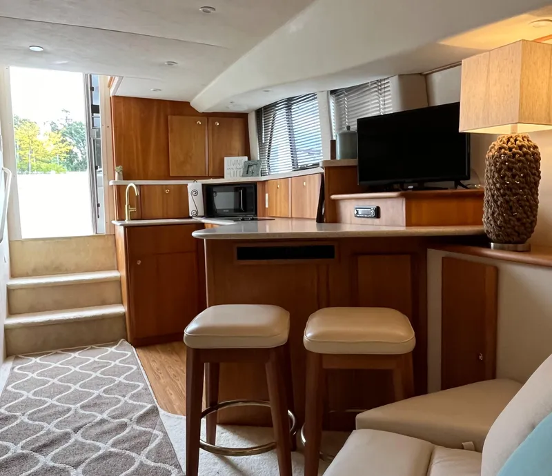 Slide: The Image of Interior of 1999 Silverton 330 Sport Bridge yacht with modern kitchen and seating area. - 12