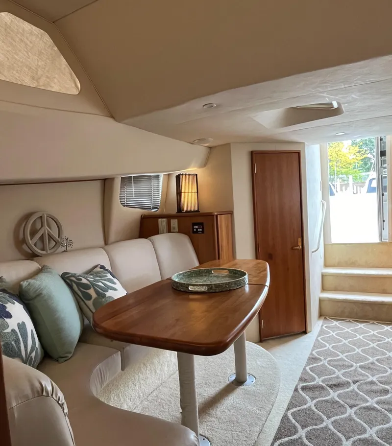 Slide: The Image of Interior of 1999 Silverton 330 Sport Bridge with cozy seating and wooden table. - 13