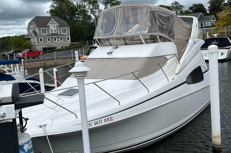 Slide: The Image of 1999 Silverton 330 Sport Bridge yacht docked at marina, featuring sleek design and covered bridge. - 15