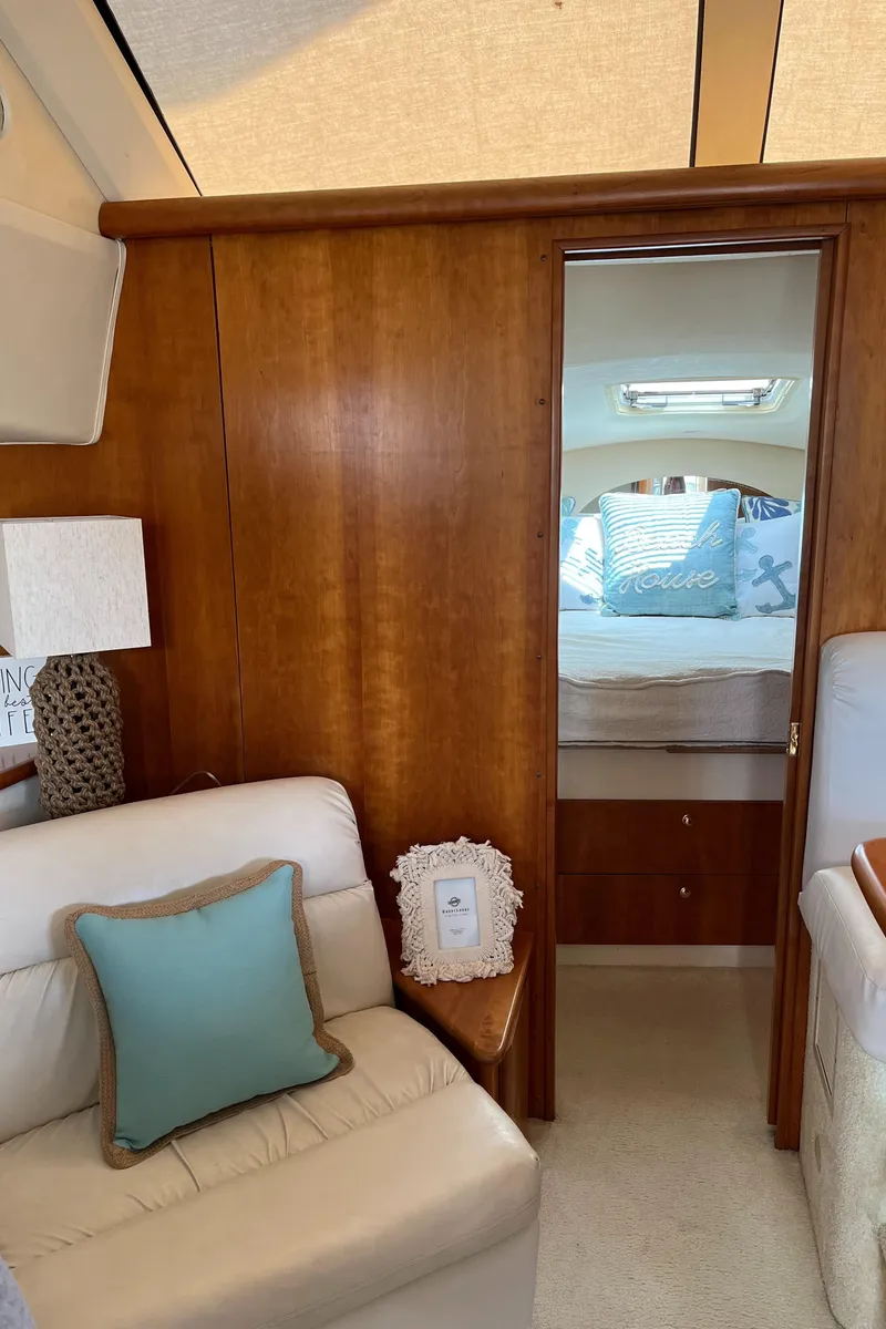 Slide: The Image of Interior of 1999 Silverton 330 Sport Bridge yacht with cozy seating and bedroom view. - 19