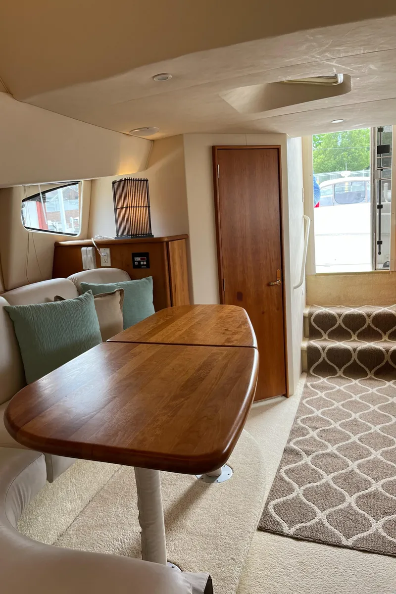 Slide: The Image of Interior of 1999 Silverton 330 Sport Bridge with wooden table and carpeted stairs. - 20