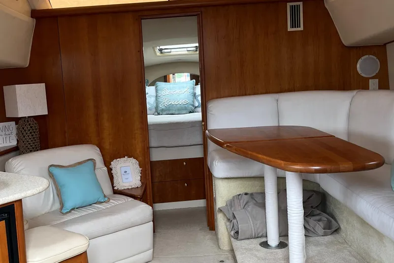 Slide: The Image of Interior of 1999 Silverton 330 Sport Bridge yacht with cozy seating and wooden table. - 22
