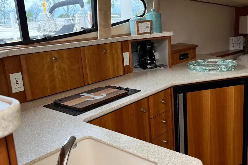 Slide: The Image of 1999 Silverton 330 Sport Bridge kitchen with wood cabinets and countertop accessories. - 23