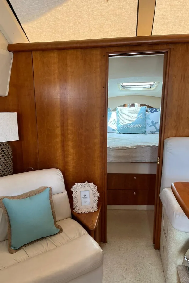 Slide: The Image of Interior of 1999 Silverton 330 Sport Bridge yacht with cozy seating and bedroom view. - 26
