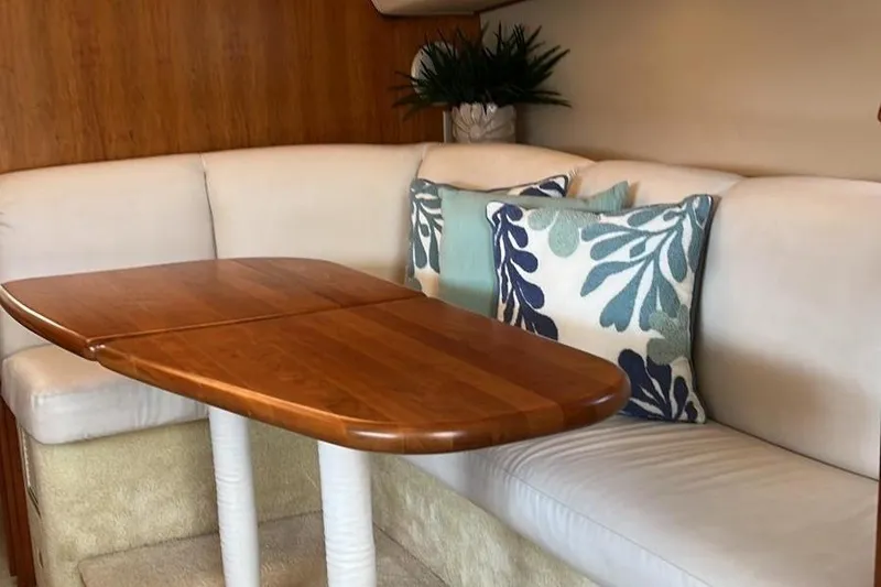 Slide: The Image of 1999 Silverton 330 Sport Bridge interior with wooden table and cushioned seating. - 27