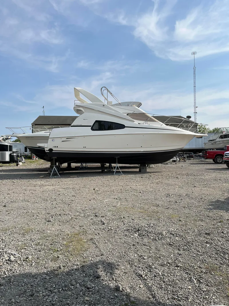 Slide: The Image of 1999 Silverton 330 Sport Bridge yacht on dry dock under a clear sky. - 28