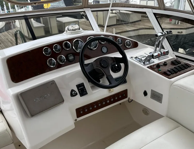 Slide: The Image of 1999 Silverton 330 Sport Bridge helm with steering wheel and control panel. - 4