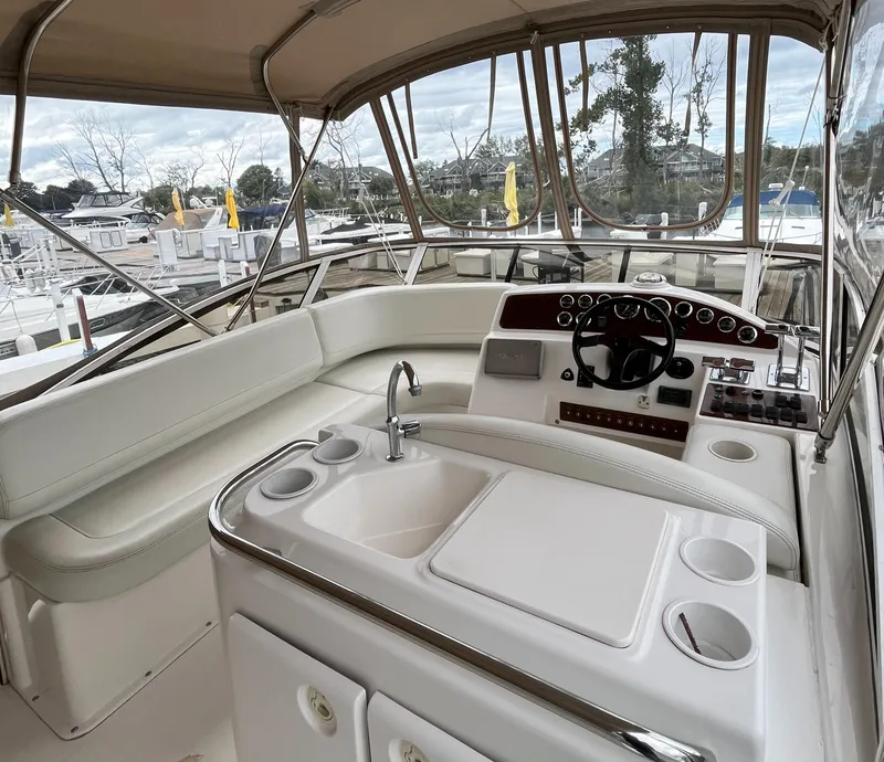 Slide: The Image of 1999 Silverton 330 Sport Bridge interior with helm, sink, and seating area. - 5