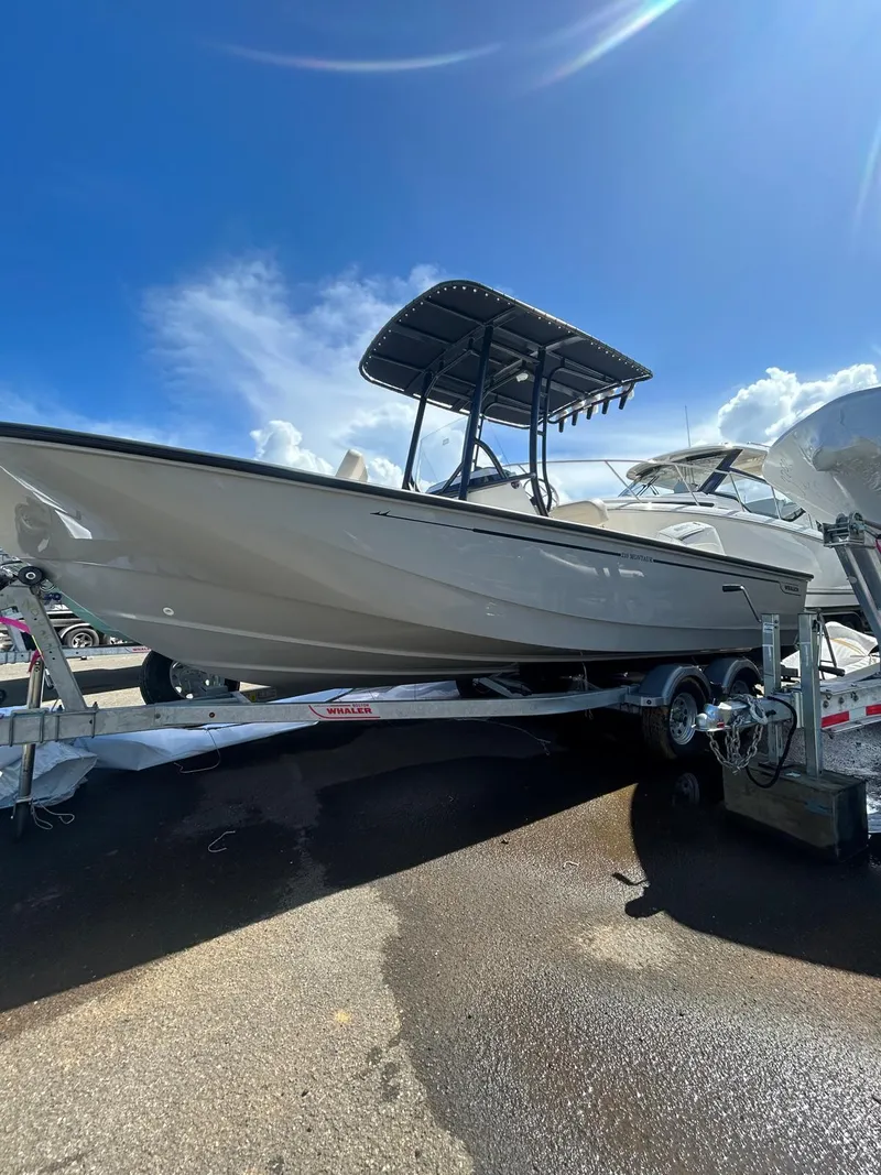 The Image of 2025 Boston Whaler 210 Montauk boat on trailer under clear blue sky. - 1
