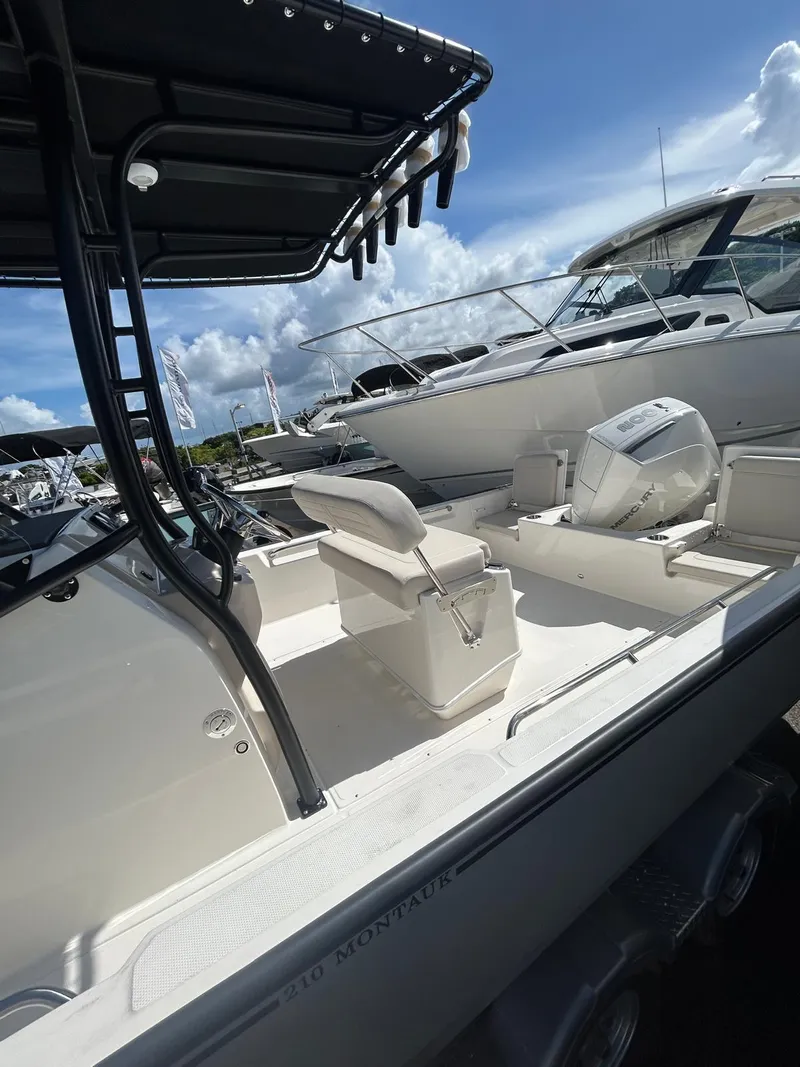 Slide: The Image of 2025 Boston Whaler 210 Montauk boat with seating, under a clear blue sky. - 3