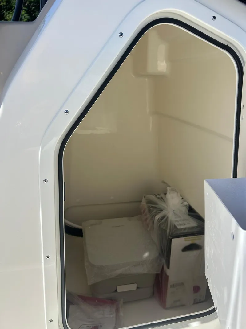 Slide: The Image of Storage compartment of 2025 Boston Whaler 210 Montauk boat, showing interior space. - 6