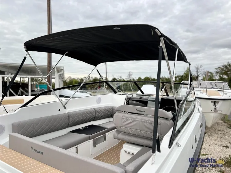 Slide: The Image of 2024 Yamarin 67 DC boat with black canopy and modern seating, docked outdoors. - 10