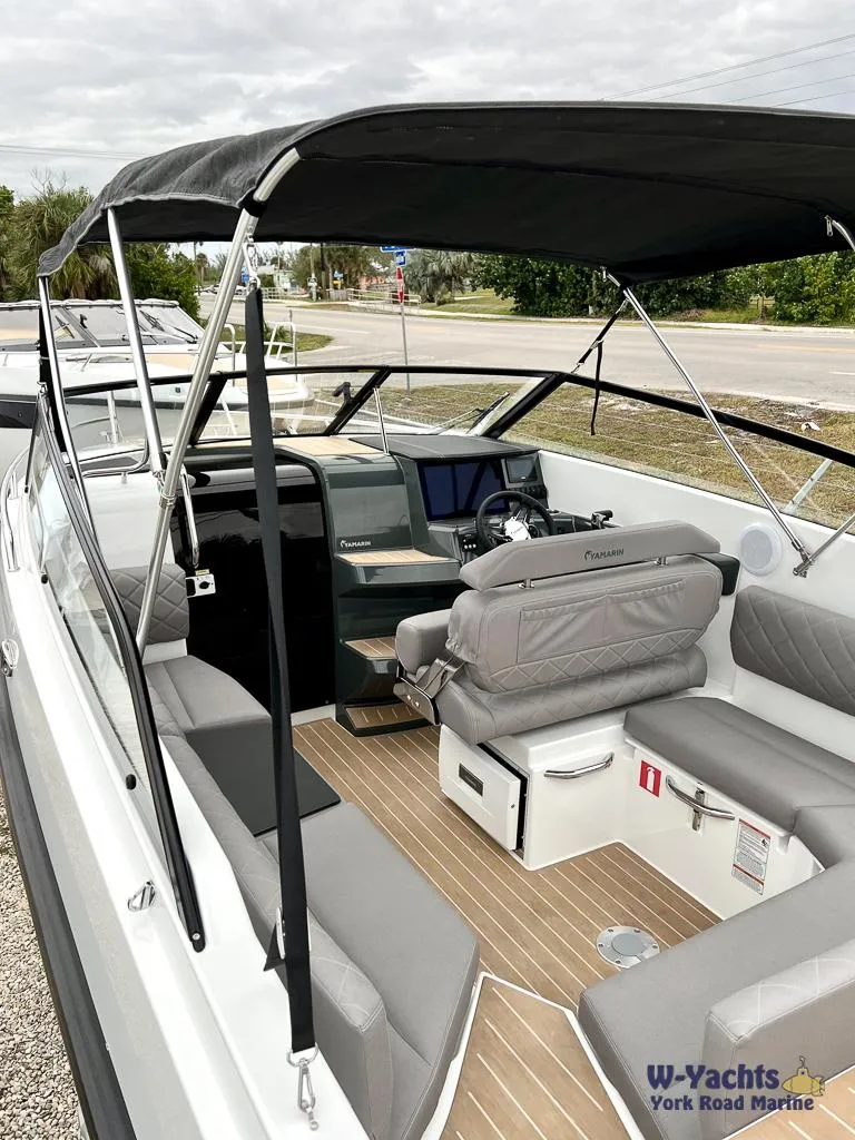 Slide: The Image of 2024 Yamarin 67 DC boat with canopy, modern seating, and sleek dashboard. - 11