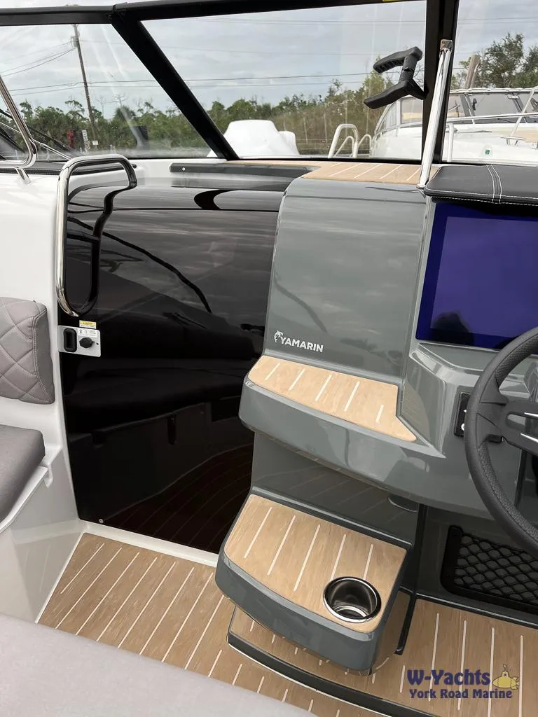 Slide: The Image of 2024 Yamarin 67 DC boat interior with modern dashboard and wood accents. - 13