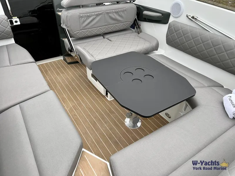 Slide: The Image of 2024 Yamarin 67 DC boat interior with gray seating and a sleek black table. - 14