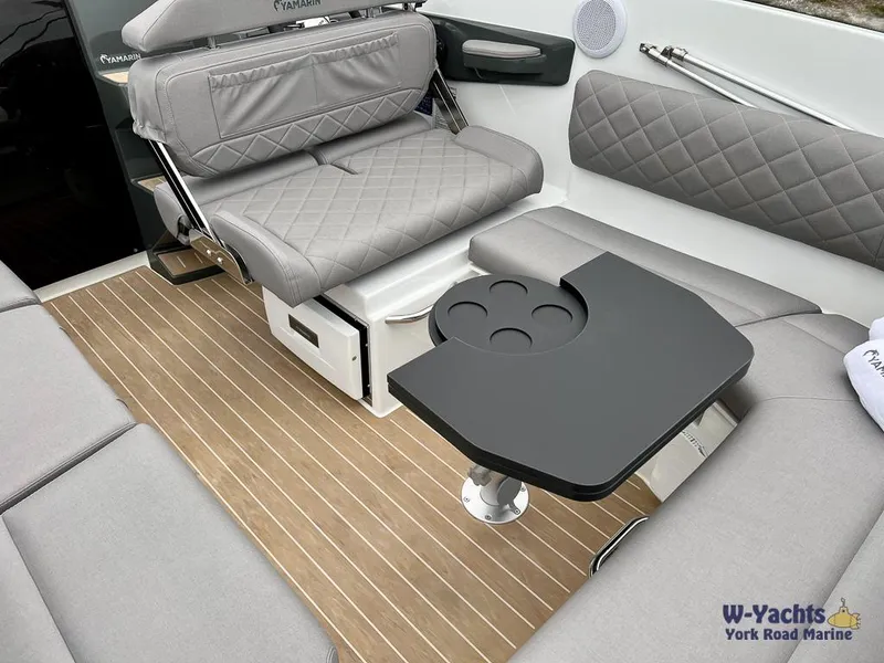 Slide: The Image of 2024 Yamarin 67 DC boat interior with gray seating and a compact black table. - 15