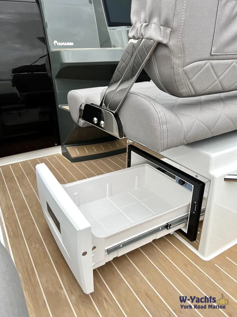 Slide: The Image of 2024 Yamarin 67 DC boat interior with open storage drawer and cushioned seating. - 17