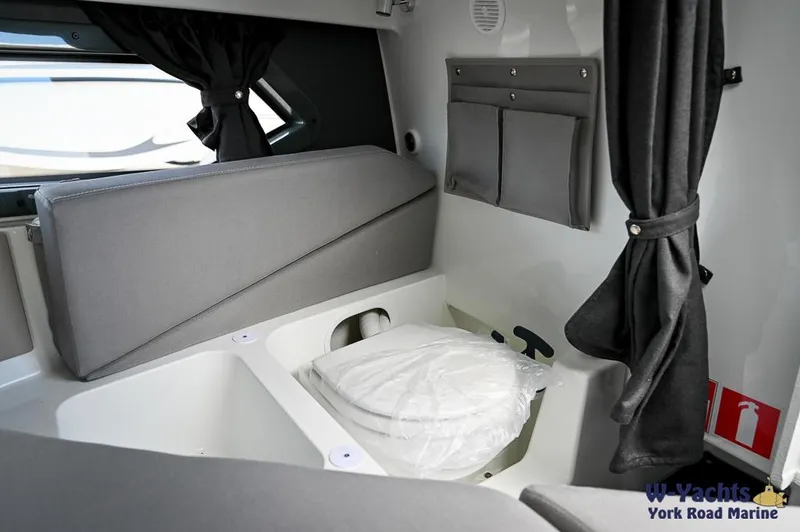 Slide: The Image of 2024 Yamarin 67 DC boat interior with compact cabin and seating area. - 19