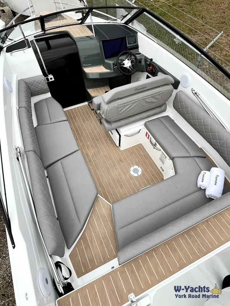 Slide: The Image of 2024 Yamarin 67 DC boat interior with gray seating and wood-style flooring. - 3