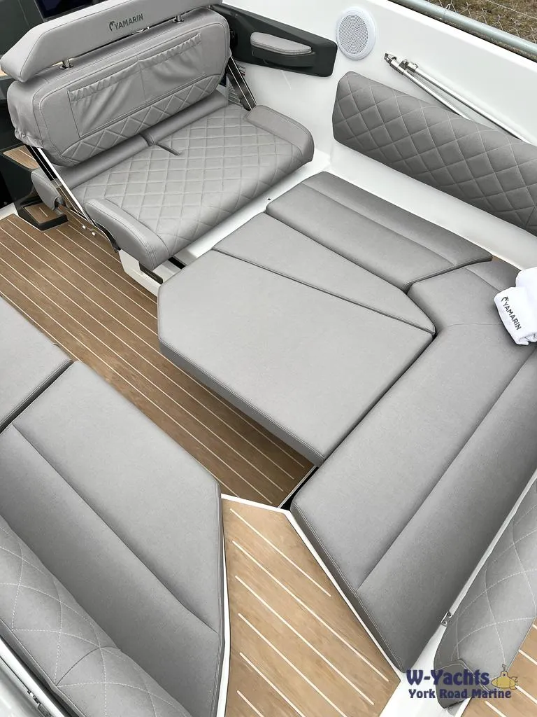 Slide: The Image of 2024 Yamarin 67 DC boat interior with gray quilted seating and wood-style flooring. - 4