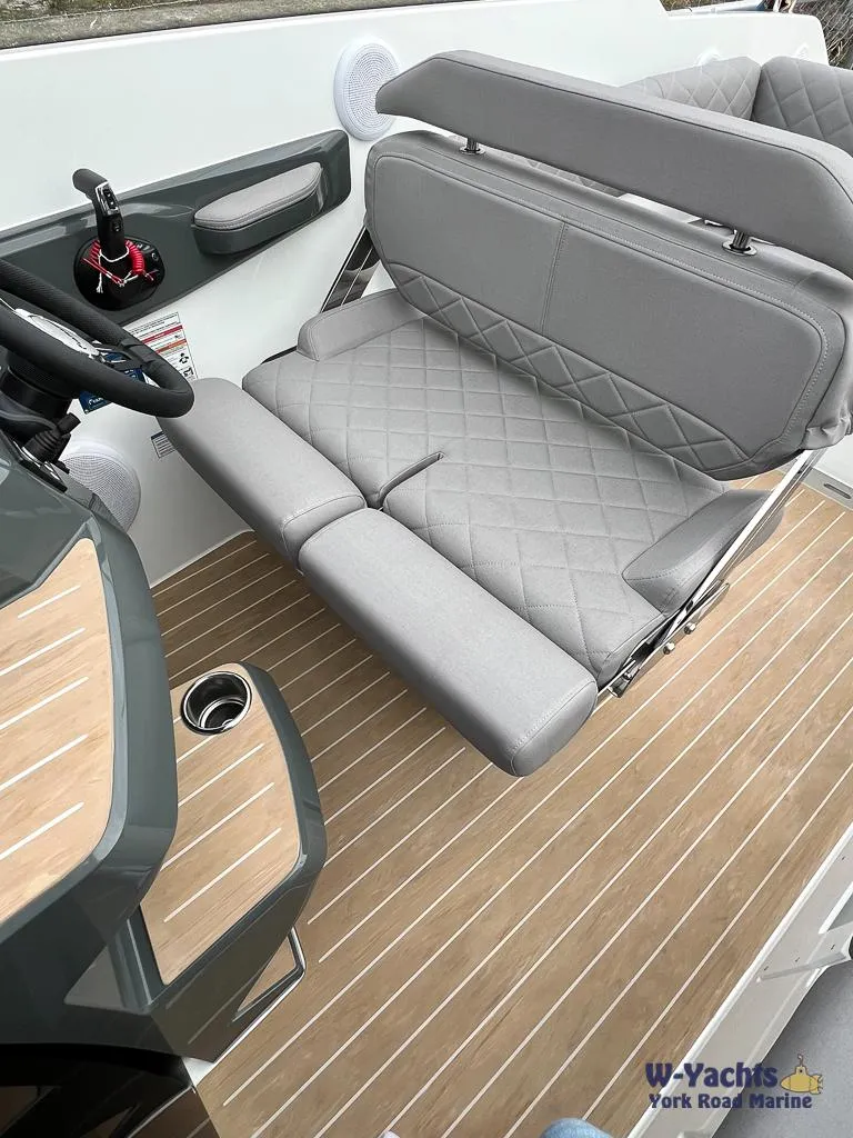 Slide: The Image of 2024 Yamarin 67 DC boat interior with gray seating and wood-style flooring. - 5