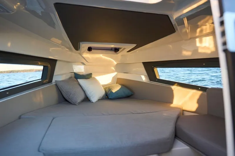 Slide: The Image of 2024 Yamarin 67 DC cabin interior with cozy seating and cushions, overlooking the water. - 6