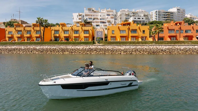 Slide: The Image of 2024 Yamarin 67 DC boat cruising near colorful waterfront buildings. - 8