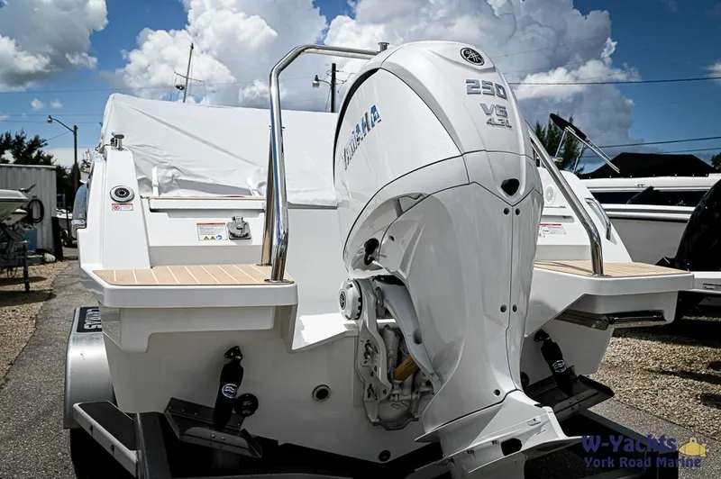 Slide: The Image of 2024 Yamarin 67 DC boat with Yamaha 250 V6 engine, parked outdoors under a cloudy sky. - 9