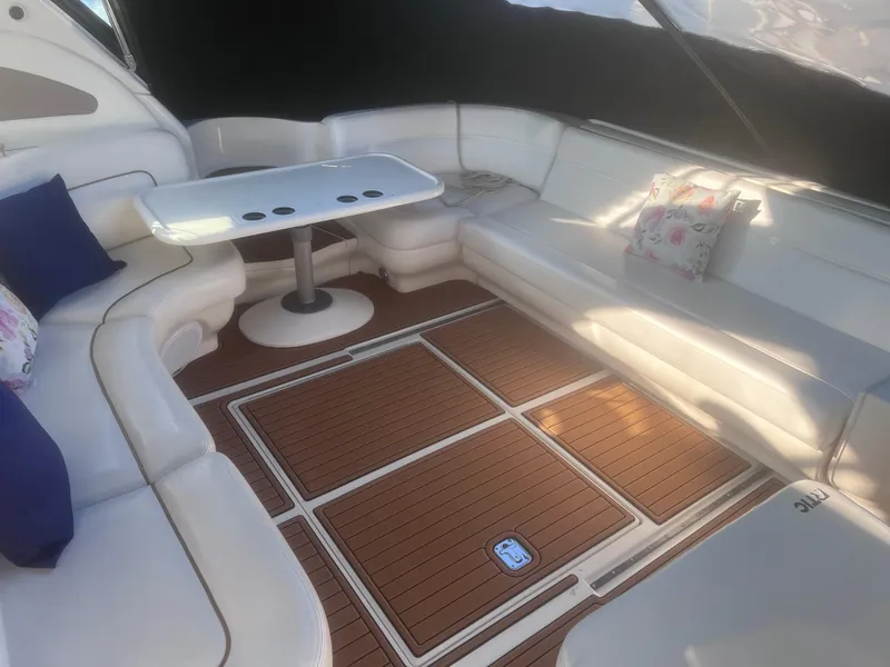 Slide: The Image of Interior seating of 2000 Sea Ray 460 Sundancer with white cushions and wooden flooring. - 14