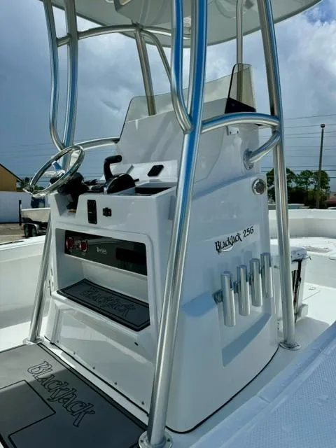 Slide: The Image of 2025 BlackJack 256 Coastal boat console with steering wheel and rod holders. - 10