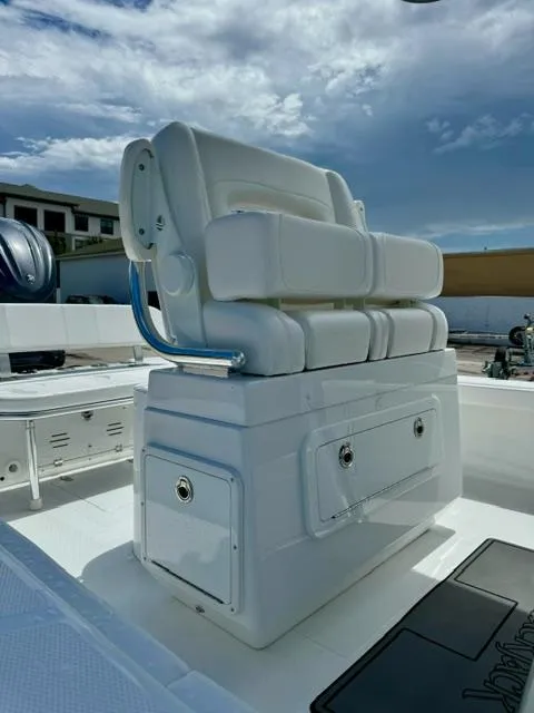 Slide: The Image of 2025 BlackJack 256 Coastal boat with cushioned seating and storage, under a partly cloudy sky. - 11