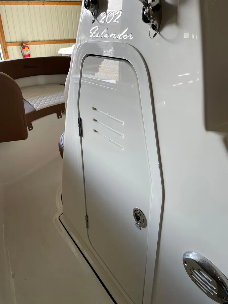 Slide: The Image of 2024 Pioneer 202 Islander boat interior with storage compartment and seating. - 10