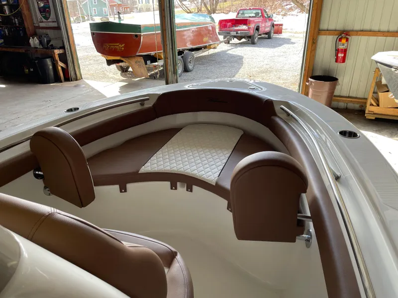 Slide: The Image of 2024 Pioneer 202 Islander boat interior with brown seating in a garage setting. - 3