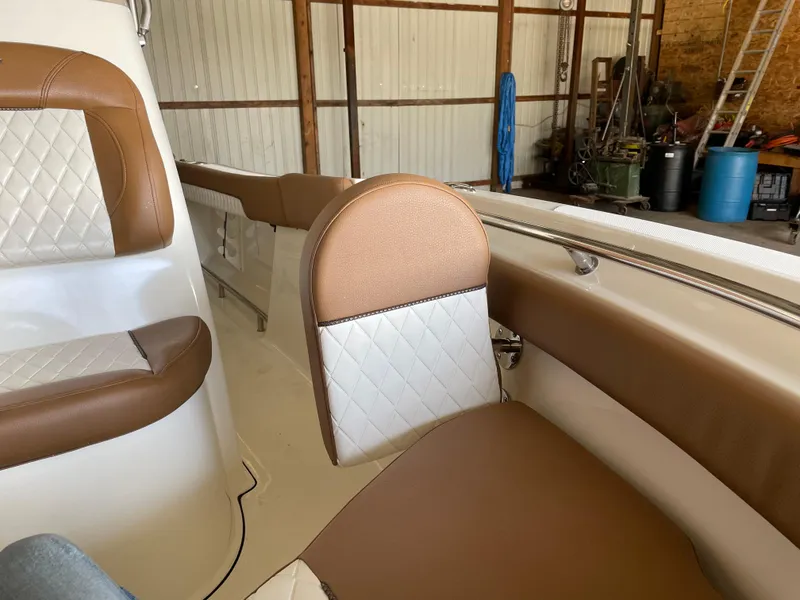 Slide: The Image of 2024 Pioneer 202 Islander boat interior with brown and white seating in a storage area. - 7