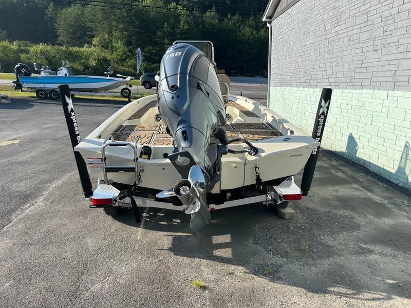 Slide: The Image of 2025 Xpress H20 BAY boat with powerful outboard motor, parked outdoors. - 4