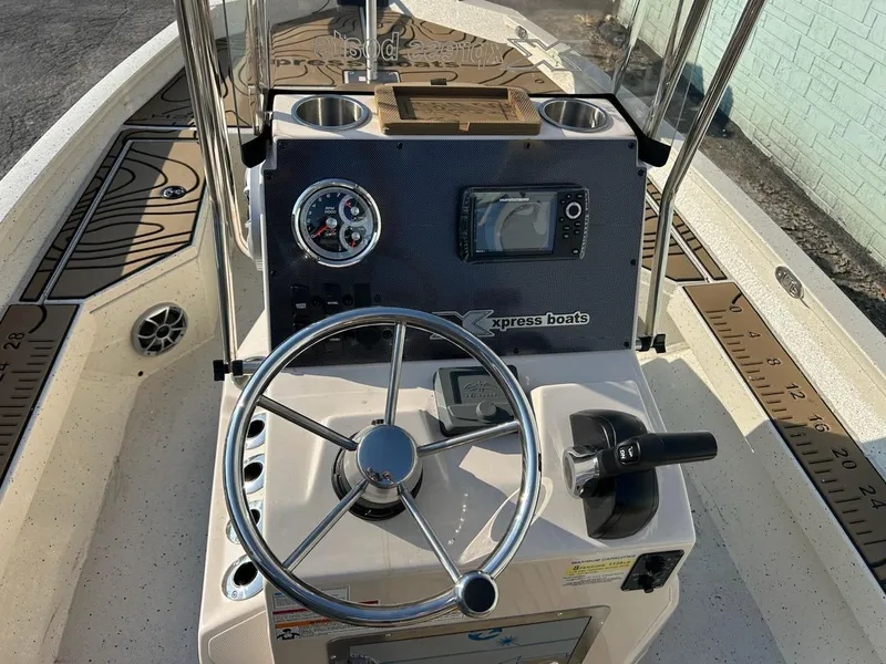 Slide: The Image of 2025 Xpress H20 BAY boat dashboard with steering wheel and controls. - 7