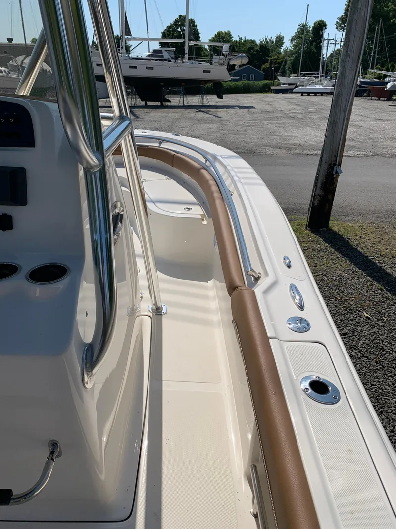 Slide: The Image of 2024 Pioneer 222 Islander boat, sleek design, docked in a marina under clear skies. - 16