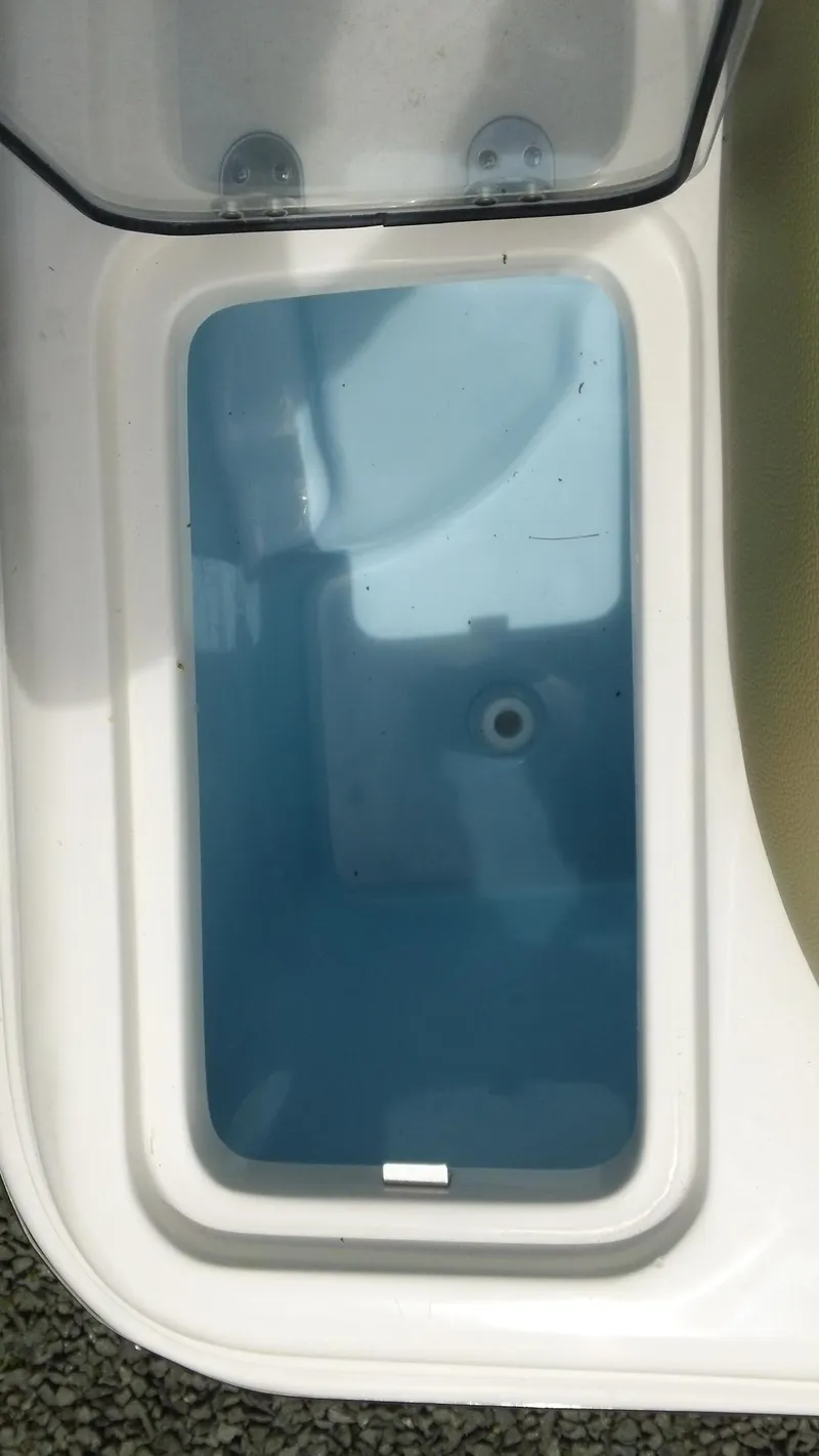 Slide: The Image of 2024 Pioneer 222 Islander boat storage compartment with blue interior. - 18