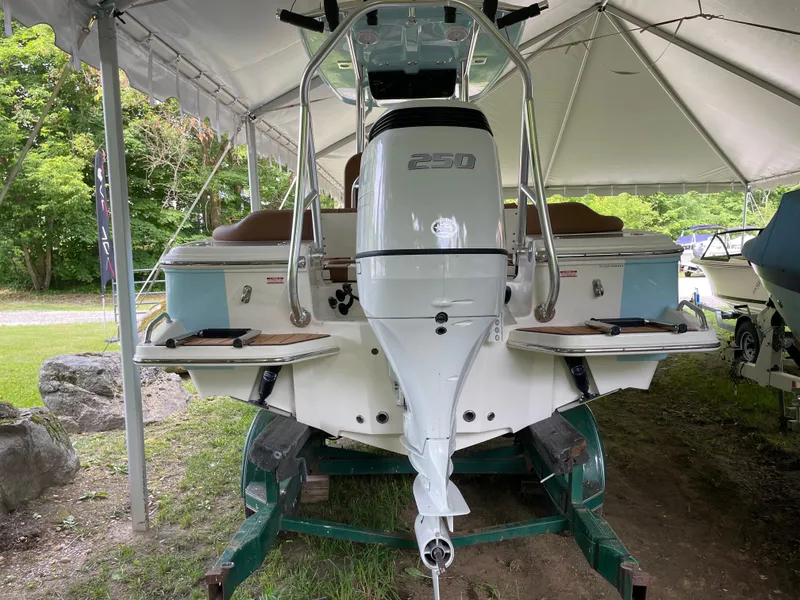 Slide: The Image of 2024 Pioneer 222 Islander boat under canopy, rear view with outboard motor. - 26