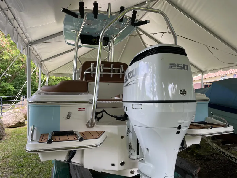 Slide: The Image of 2024 Pioneer 222 Islander boat with Suzuki 250 outboard motor under a canopy. - 27