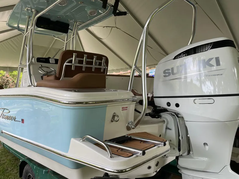 Slide: The Image of 2024 Pioneer 222 Islander boat with Suzuki outboard motor under a canopy. - 29