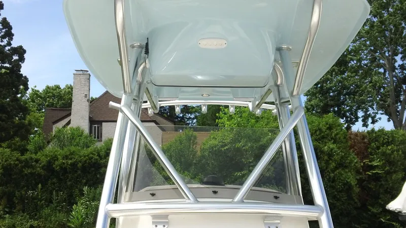 Slide: The Image of 2024 Pioneer 222 Islander boat with T-top and windshield, surrounded by greenery. - 3