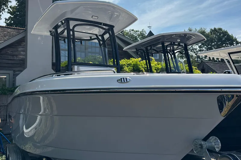 The Image of 2025 Robalo R222 Explorer boat with dual T-tops, docked outdoors. - 0